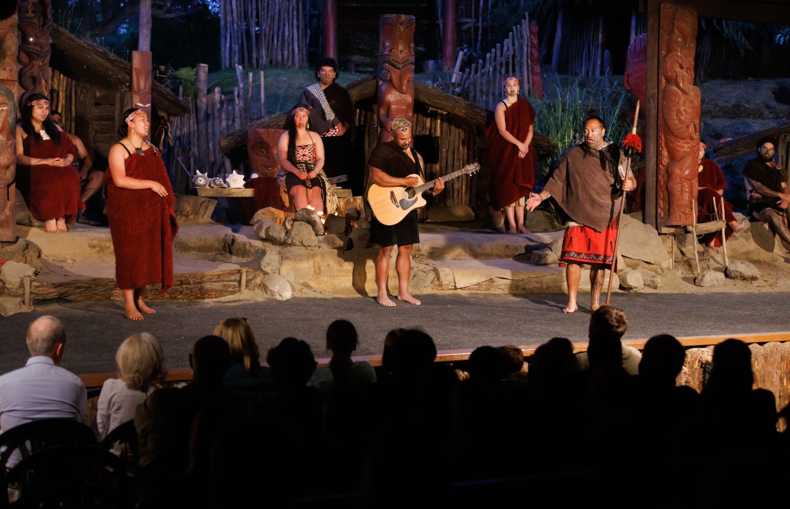 a group of people watching a band on stage in front of a crowd